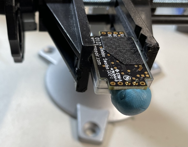 SenseAir S8 held in a vice with header pins held in place for soldering using blu tack