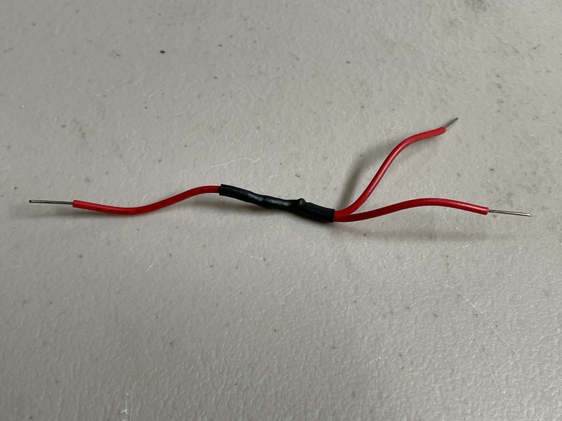3 22-gauge red wires soldered together, with the soldering joint covered with black heat-shrink tubing